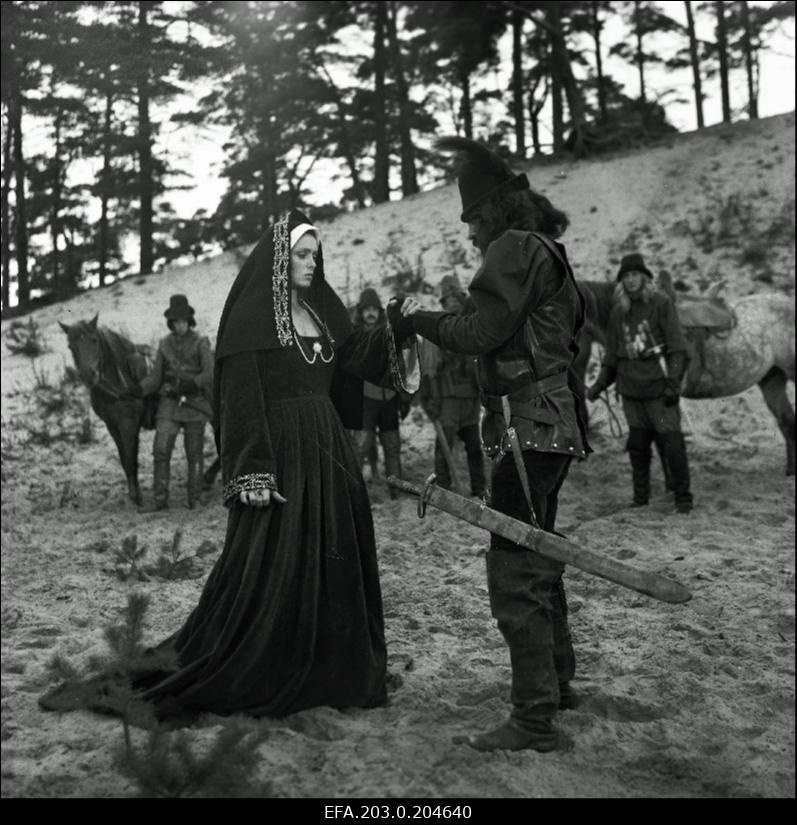 Stseen Tallinnfilmi mängufilmist "Hundiseaduse aegu". Esiplaanil Liisa Pesentack - Regina Razuma, Hans Metten - Jüri Krjukov.