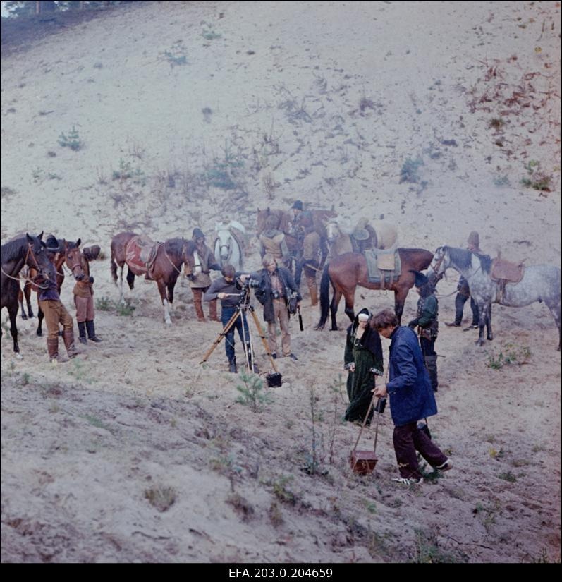 Tallinnfilmi mängufilmi "Hundiseaduse aegu" filmimine. Kaamerat sätib operaator-lavastaja Edvard Oja, tema kõrval seisab helioperaatori assistent Mati Jaska, esiplaanil näitlejate Regina Razuma ja Jüri Krjukovi ees teine operaator Rainer Tomik.