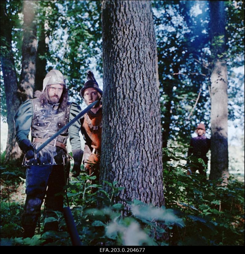 Stseen Tallinnfilmi mängufilmist "Hundiseaduse aegu". Puu taga seisavad Hans Metten (Jüri Krjukov) ja Hermann Pesentack (Egon Nuter).