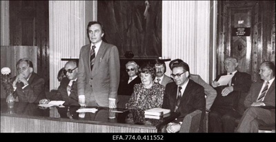 Eesti Geograafia Seltsi 30. aastapäeva pidulikul koosolekul Eesti NSV Teaduste Akadeemia saalis (Kohtu 6) kõneleb seltsi president Jaan-Mati Punning; istuvad (vasakult) akadeemikud  Raimund Hagelberg ja Juhan Kahk, teadussekretär Laine Merikalju, asepresident Anto Raukas, professor Salme Nõmmik (tagareas), teadur Hardo Aasmäe, professor Endel Varep ja majandusdoktor Vello Tarmisto.  similar photo