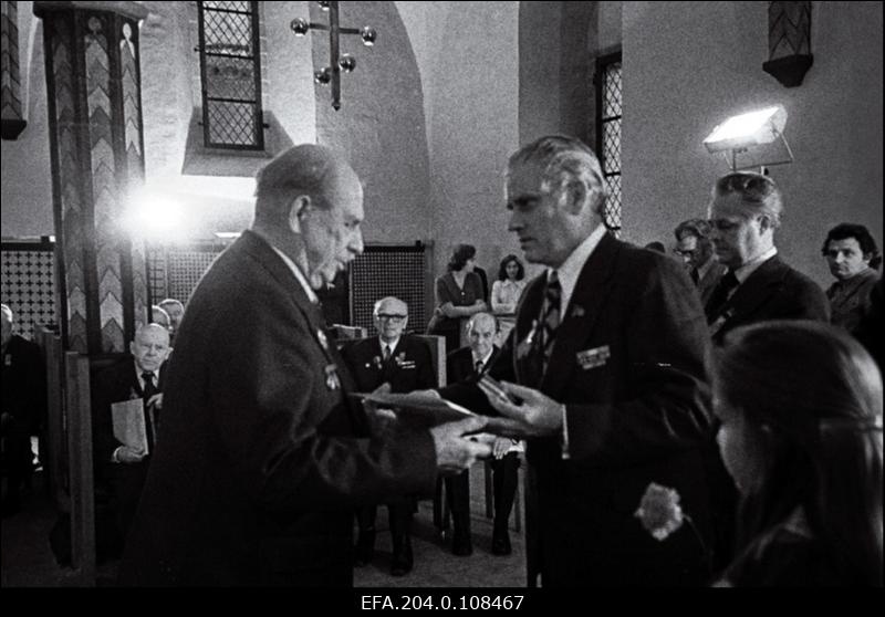 Revolutsioonilise liikumise ja kodusõja veteranide vastuvõtul Tallinna Raekojas annab EKP Tallinna Linnakomitee esimene sekretär N. Johanson Kommunistliku Partei liikmele 1917.a. G. Gustavsonile üle tervitusaadressi ja kingituse.