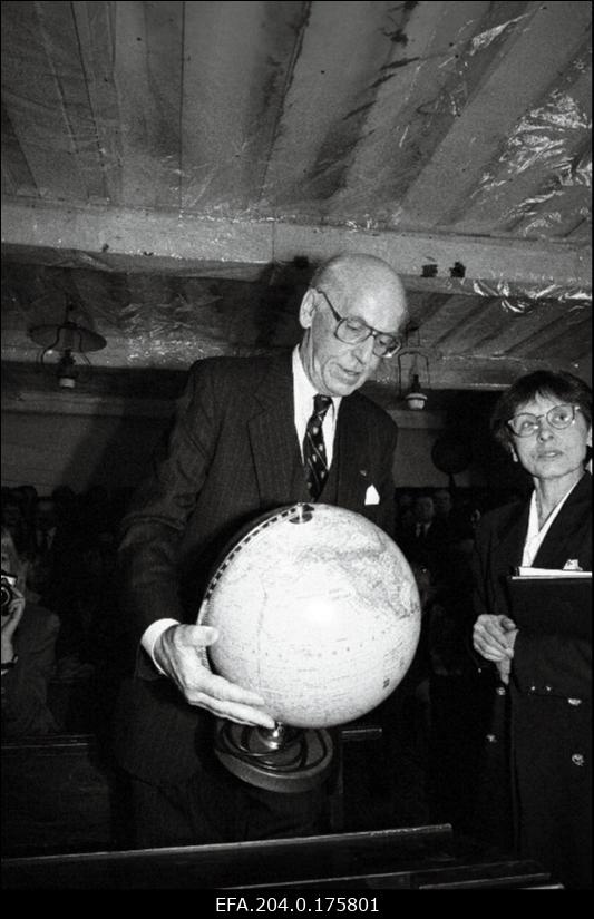 President Lennart Meri toob kingituseks Palamuse O. Lutsu Kihelkonnakoolimuuseumile gloobuse. Paremal presidendi pressinõunik Piret Saluri.