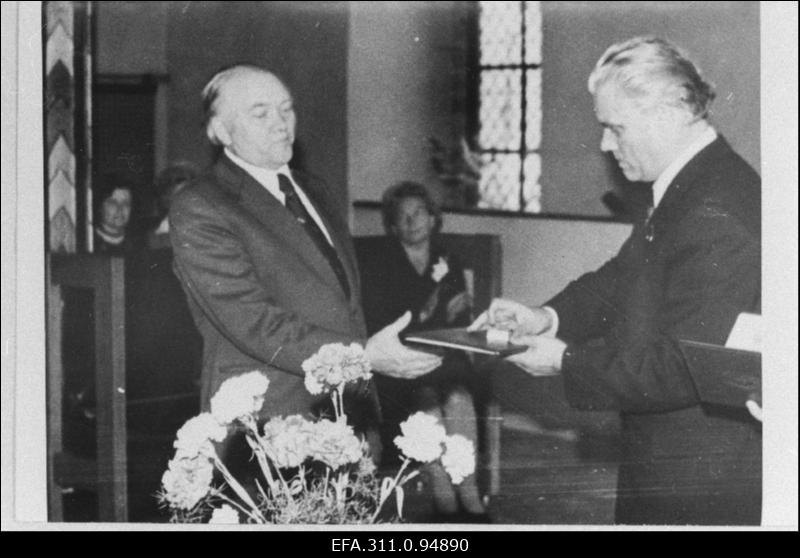 EKP Tallinna Linnakomitee esimene sekretär Nikolai Johanson üle andmas Tallinna 39. Keskkooli direktorile Arnold Maasingule Eesti NSV teenelise õpetaja tunnistust ja märki õpetajate vastuvõtul Raekojas.