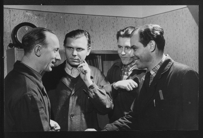 Tallinna Kontroll-Mõõteriistade Katsetehase kommunistliku töö eesrindlase nimetuse saanud töölised (vasakult) lukksepp Jakov Zolotuhhin, elektrikute brigadir Nikolai Vjuni ja elektrik Hillar Neudorf, keda õnnitleb tehase ametiühingukomitee esimees Leonhard Purre.