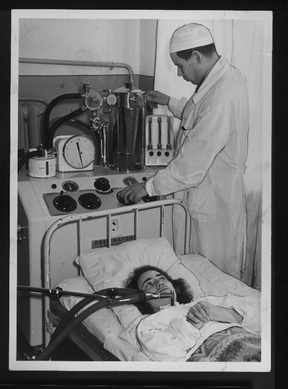 Tartu Vabariikliku Kliinilise Haigla närviosakonna hingamiskeskuses arst Arvo Tikk teostab järelravi poliomüeliidi tagajärjel hingamislihaste halvatust põdenud Helga Kommerile.