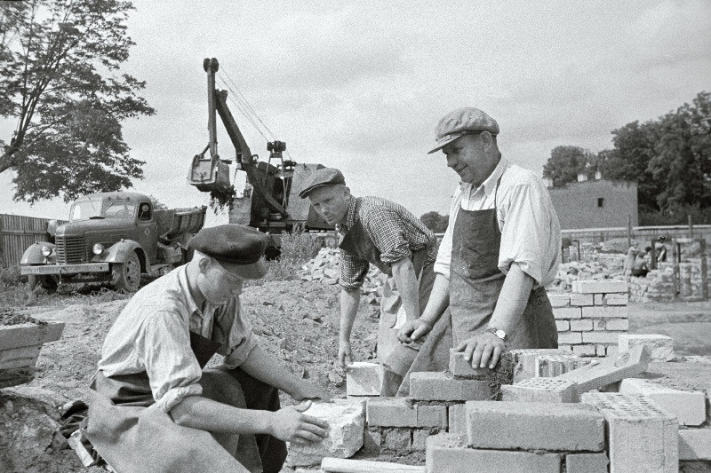 NSV Liidu Ülemnõukogu saadik vabariigi parim müüriladuja Kristjan Kärber (paremal) oma brigaadi liikmete K. Poomi (keskel) ja T. Kaskmaaga tehnikumi vundamenti ladumas Pärnu maanteel.