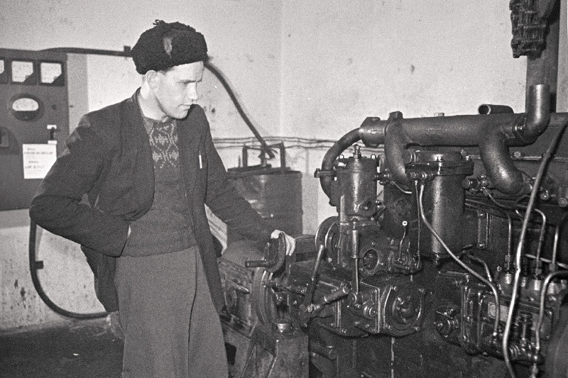 Pärnu-Jaagupi masina-traktorijaama peainsener O. Klaus mootoristendil mootorit kontrollimas.