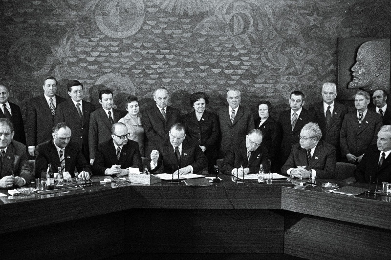 Eesti NSV ja Läti NSV töötajate 1976.a. sotsialistliku võistluse lepingule kirjutavad alla EKP Keskkomitee esimene sekretär J. Käbin (paremalt 3.) ja Läti KP Keskkomitee esimene sekretär A. Voss (paremalt 4.). Istuvad paremalt 1. ENSV Ministrite Nõukogu esimees V. Klauson, 2. ENSV Ülemnõukogu Presiidiumi esimees A. Vader. Seisavad paremalt 1. ENSV Ministrite Nõukogu esimehe asetäitja A. Green, 3. ENSV Ministrite Nõukogu esimehe asetäitja V. Käo, 4. ENSV Ministrite Nõukogu esimehe esimene asetäitja E. Tõnurist, 7. ENSV Ülemnõukogu Presiidiumi esimehe asetäitja M. Vannas.