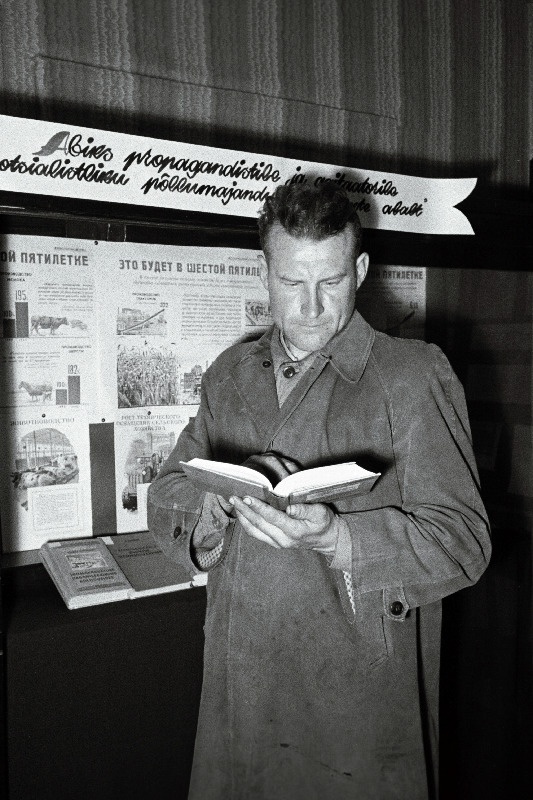 Ühise Kodu kolhoosi agronoom L. Pruus raamatukogus kirjandust valimas.