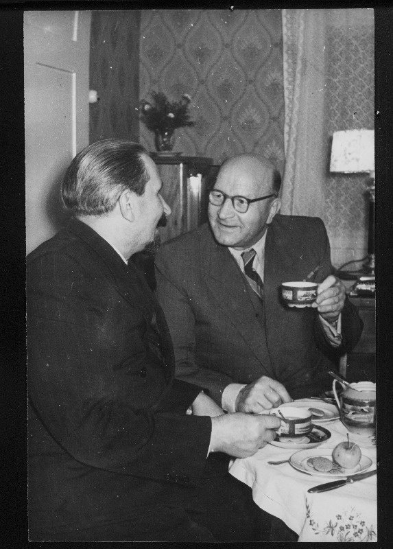 Vanad Petrogradi töölised-revolutsionäärid K. Sisko ja I. Rosenthal (keskel) meenutavad kohvilauas revolutsioonisündmusi 1917. aastal.