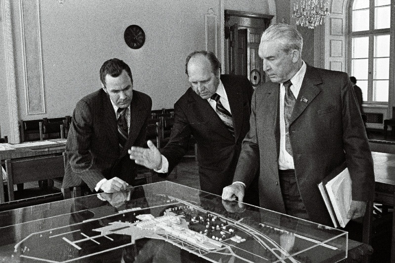 Eesti NSV Ministrite Nõukogu esimees V. Klauson (paremalt), Eesti NSV Ministrite Nõukogu esimehe asetäitja A. Green ja Eesti NSV Ministrite Nõukogu vastutav töötaja A. Mumme tutvuvad ehitatava olümpiakeskuse maketiga.