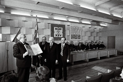 1976.a. sotsialistliku võistluse tulemuste põhjal puidutöötlemiskombinaadile "Viisnurk" määratud NLKP Keskkomitee, NSV Liidu Ministrite Nõukogu, ÜAÜKN-i ja ÜLKNÜ Keskkomitee rändpunalipu annab üle Eesti Ülemnõukogu Presiidiumi esimees A. Vader.  similar photo