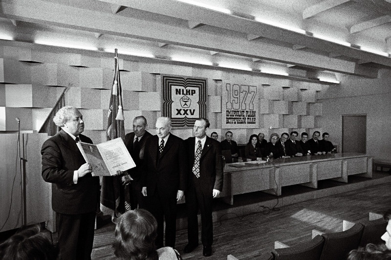 1976.a. sotsialistliku võistluse tulemuste põhjal puidutöötlemiskombinaadile "Viisnurk" määratud NLKP Keskkomitee, NSV Liidu Ministrite Nõukogu, ÜAÜKN-i ja ÜLKNÜ Keskkomitee rändpunalipu annab üle Eesti Ülemnõukogu Presiidiumi esimees A. Vader.