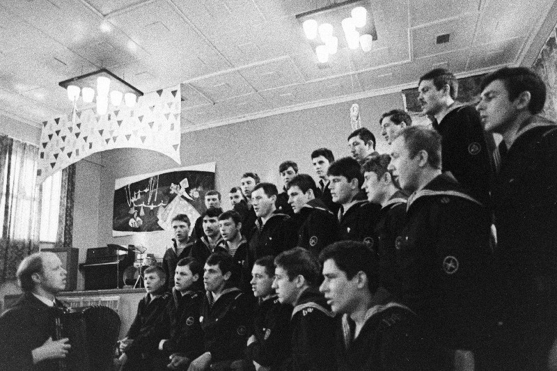 Kahekordne Punalipulise Balti Laevastiku Tallinna madruste klubi laulu- ja tantsuansambli kunstiline juht V. Tulubejev madruste kooriga harjutamas.