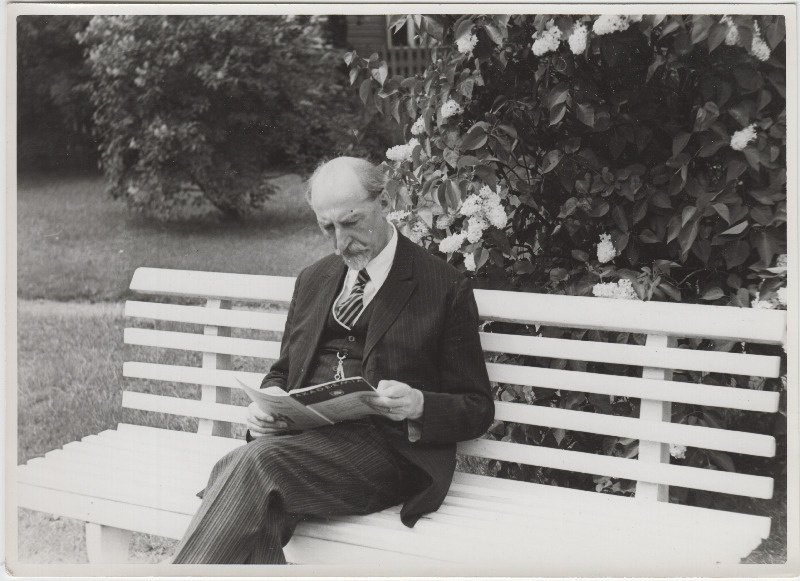 Jaan Tõnisson oma aias sirelipõõsa ees pingil Akadeemiat lugemas.