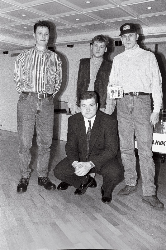 Ansambli 2 Quick Start liikmed (vasakult) Ilmar Laisaar, Pearu Paulus ja Alar Kotkas koos produtsendi Auris Rätsepaga (ees) oma esimese laserplaadi esitlusel restoranis Katamaraan.